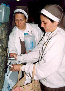Nuestra fundadora y Sister Ana recogen agua de Lourdes